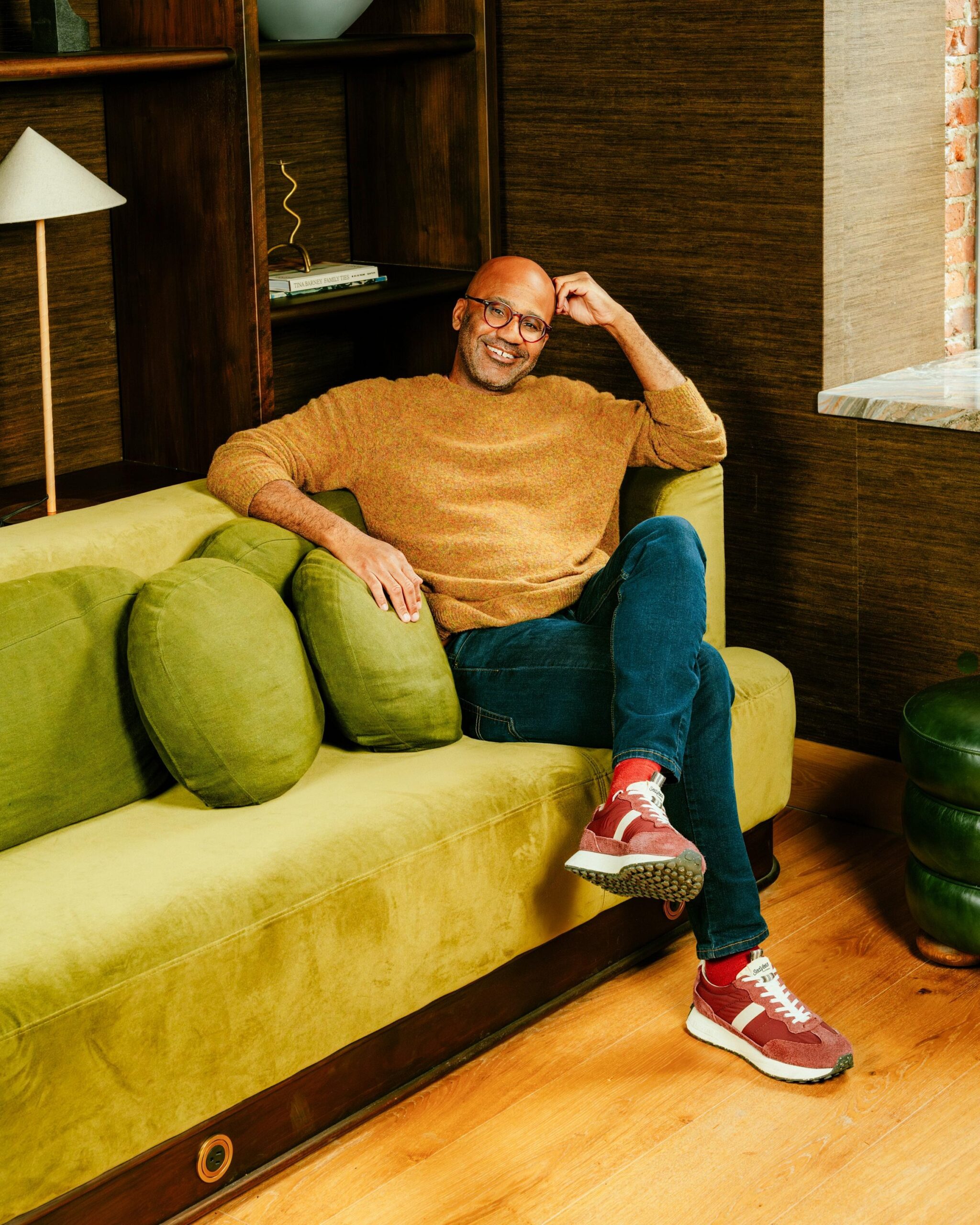 Kai Wright sitting on an objectively dope avocado green couch.