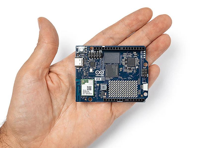 A hand holding an Arduino Uno Q computer.