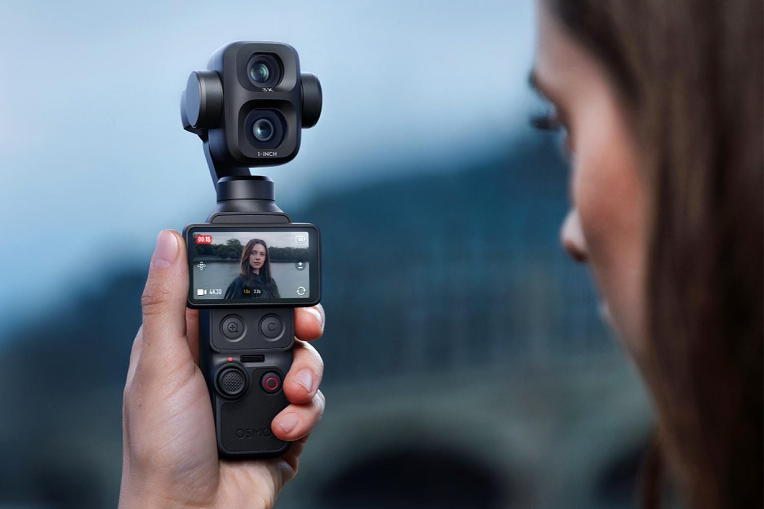 A person uses the DJI Osmo Pocket 4P camera in one hand to record themselves.