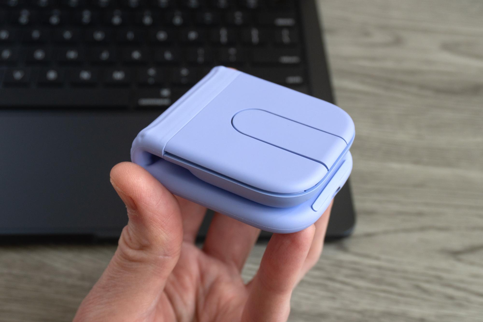 A person holds the Logitech Mobi Fold mouse in one handed while it’s folded in half. A person holds the Logitech Mobi Fold mouse in one handed while it’s folded in half.