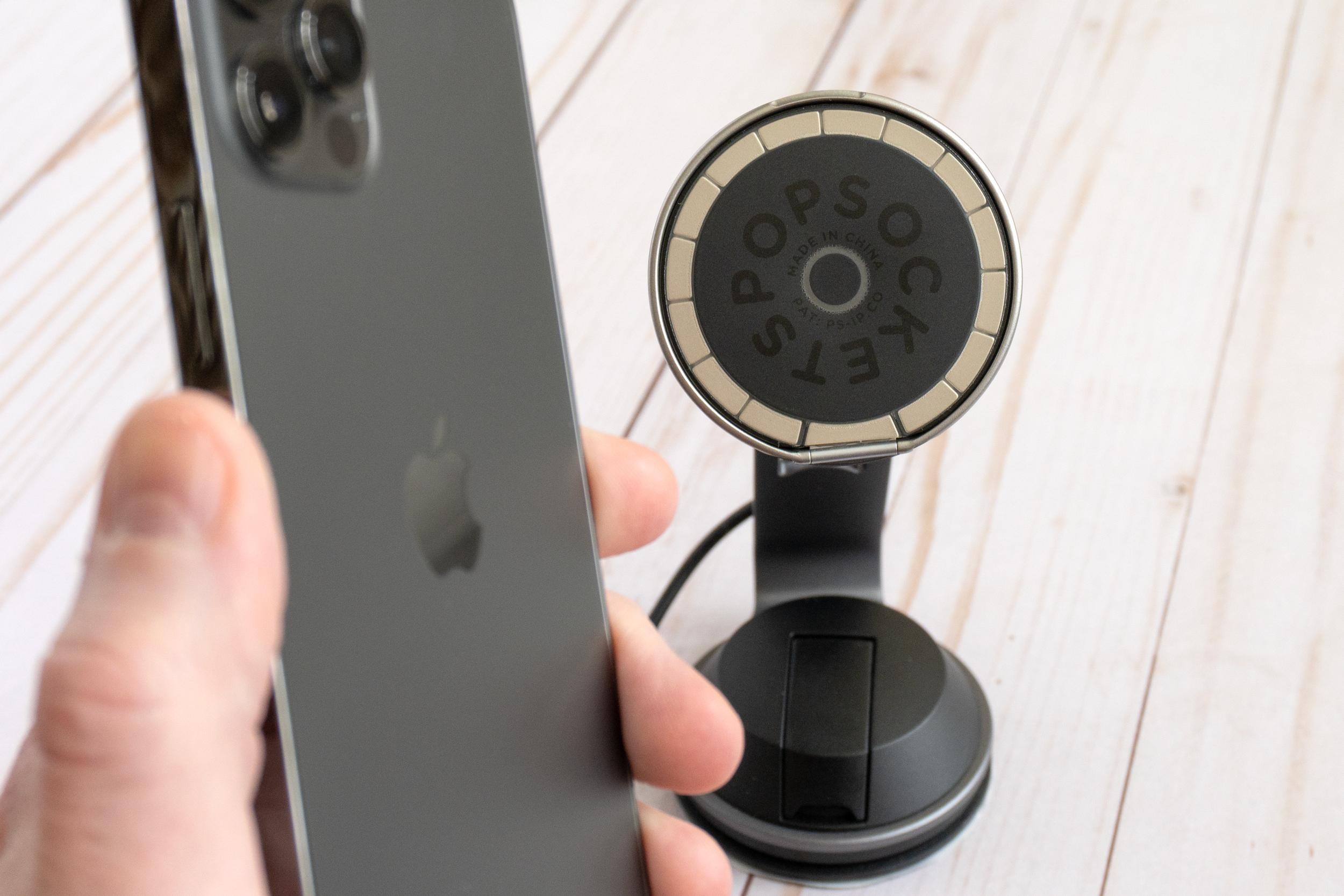 A person holding an iPhone 12 Pro with the PopSockets Low-Pro grip stuck to a magnetic phone charger. A person holding an iPhone 12 Pro with the PopSockets Low-Pro grip stuck to a magnetic phone charger.