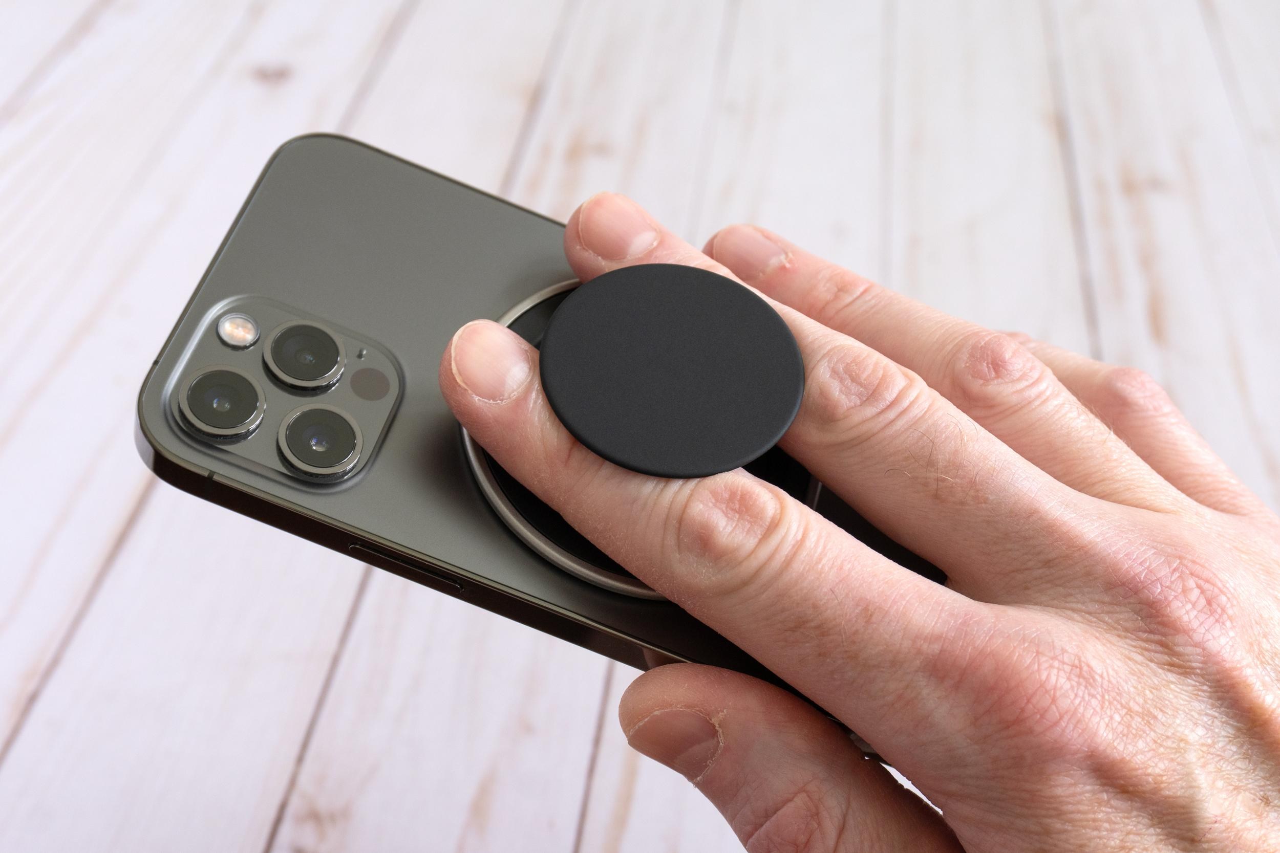 A person holds an iPhone 12 Pro using the PopSockets Low-Pro grip attached to the back. A person holds an iPhone 12 Pro using the PopSockets Low-Pro grip attached to the back.
