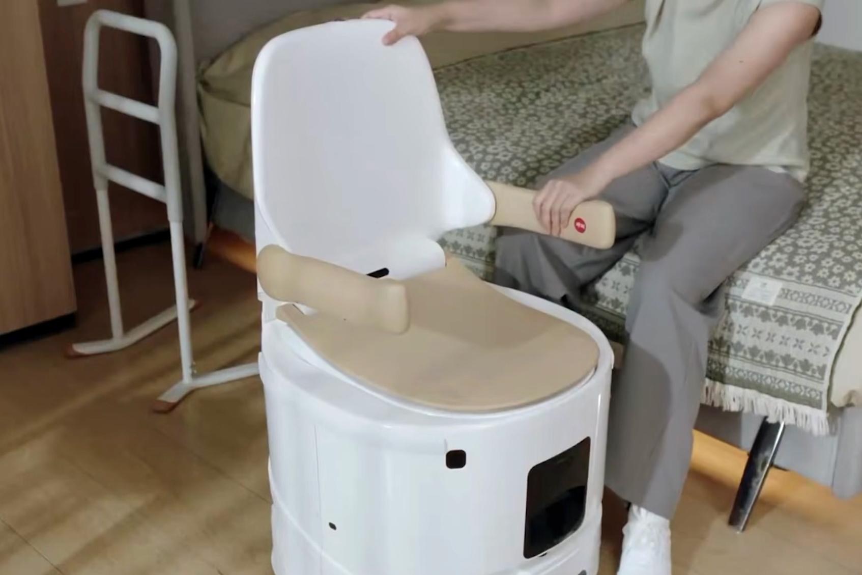 A person steadies themselves using the arm of the Xiaoban robot toilet.