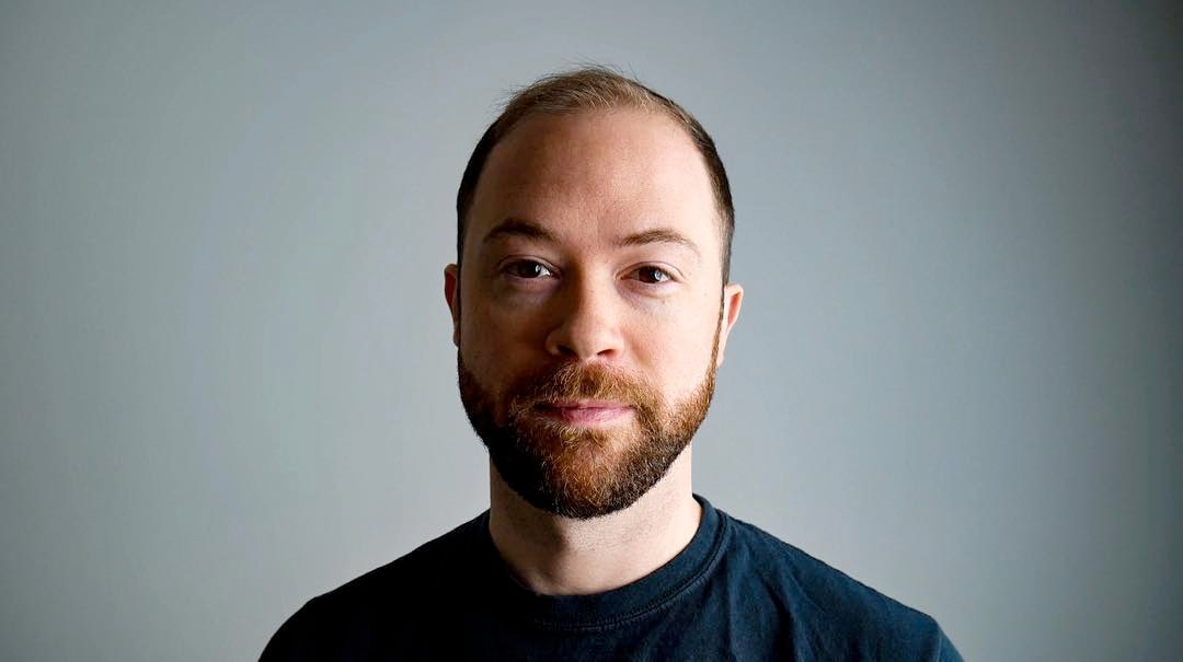 Headshot of Mike Rugnetta against a plain gray background.