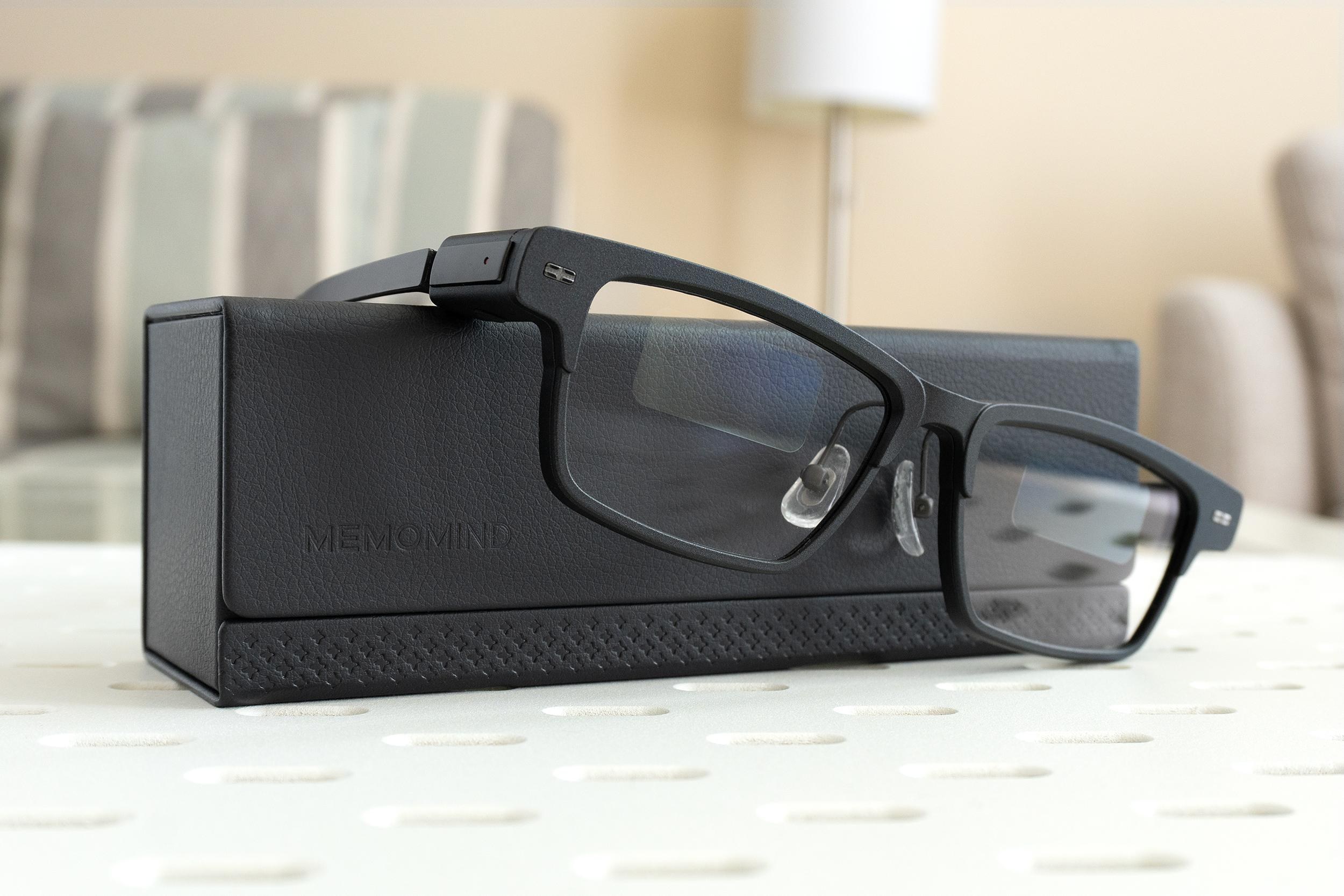 The Xgimi MemoMind One smart glasses leaning against their carrying case.