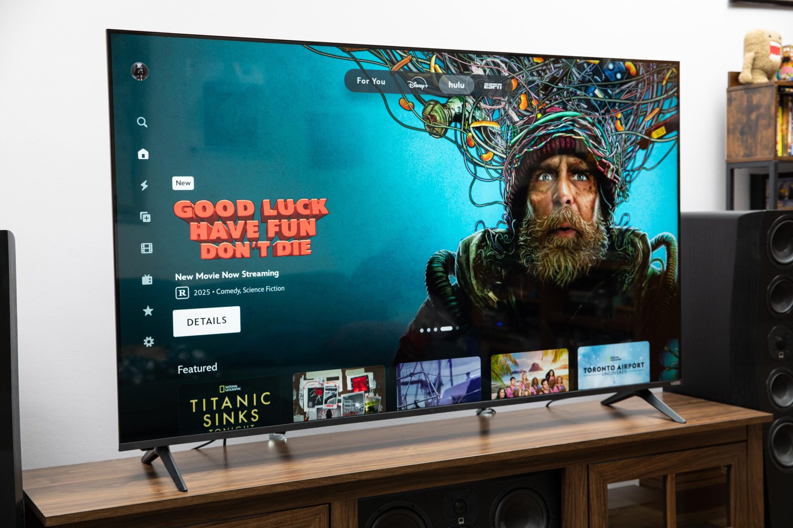 The Vizio Mini LED Quantum displaying the Vizio OS home page, on a wooden credenza.
