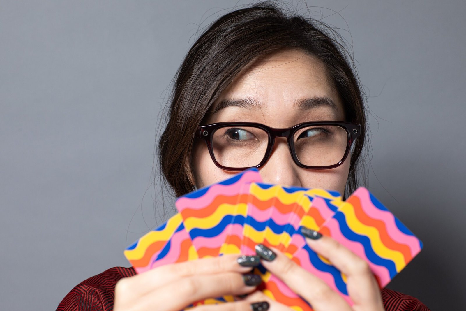 Senior reviewer Victoria Song holds playing cards while wearing the Meta Glasses adventurer.