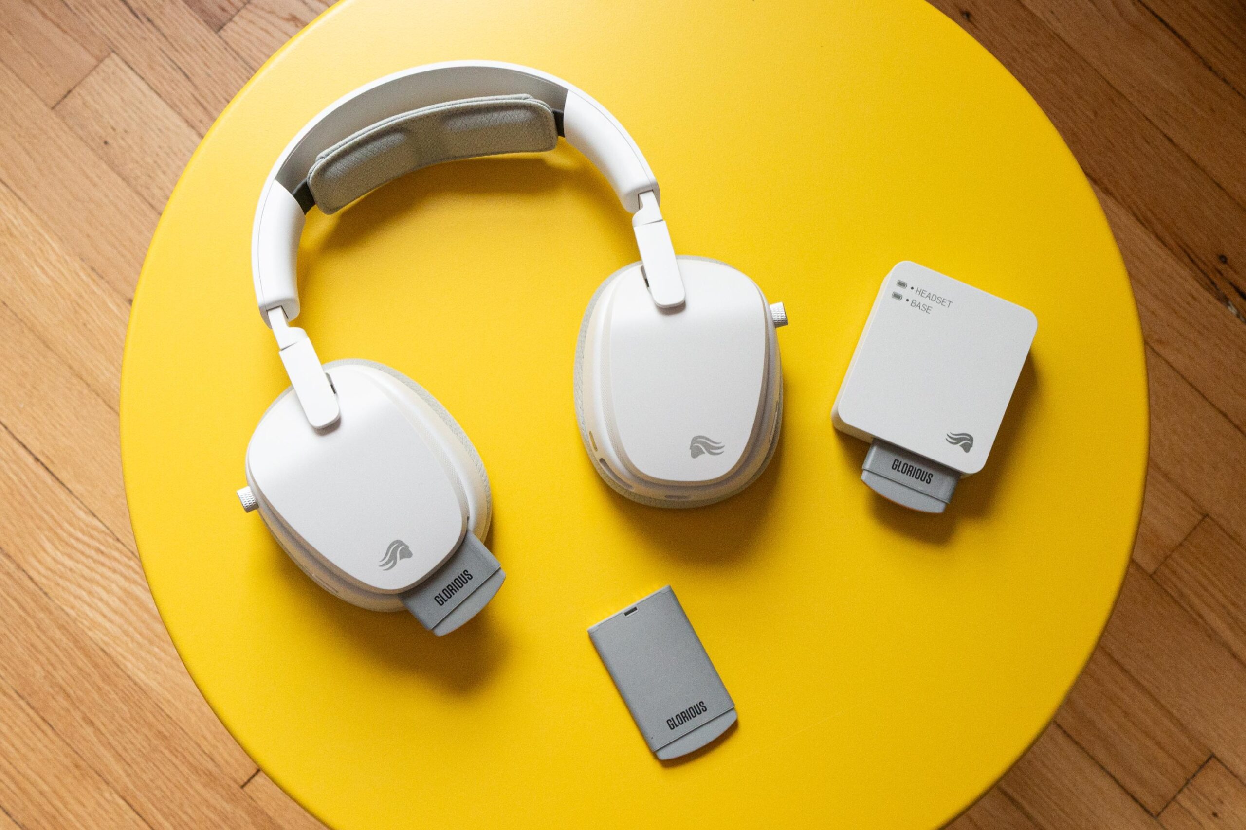 A white over-ear headset pictured with its hot-swappable battery packs.
