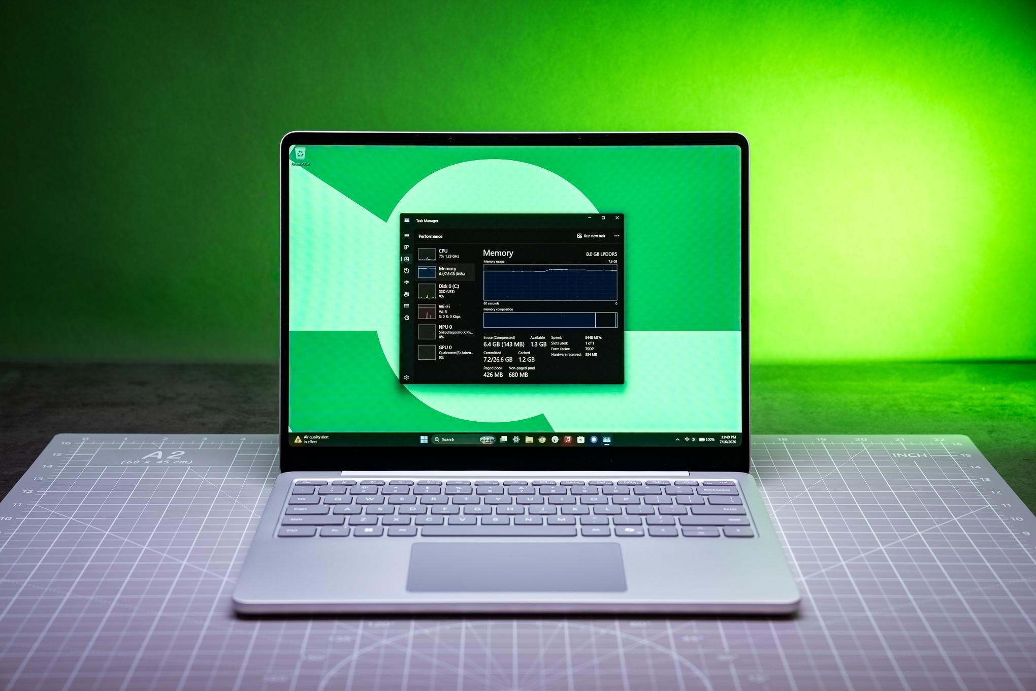 A Microsoft 13-inch Surface Laptop with performance monitoring in Task Manager open, showing the amount of memory in use.