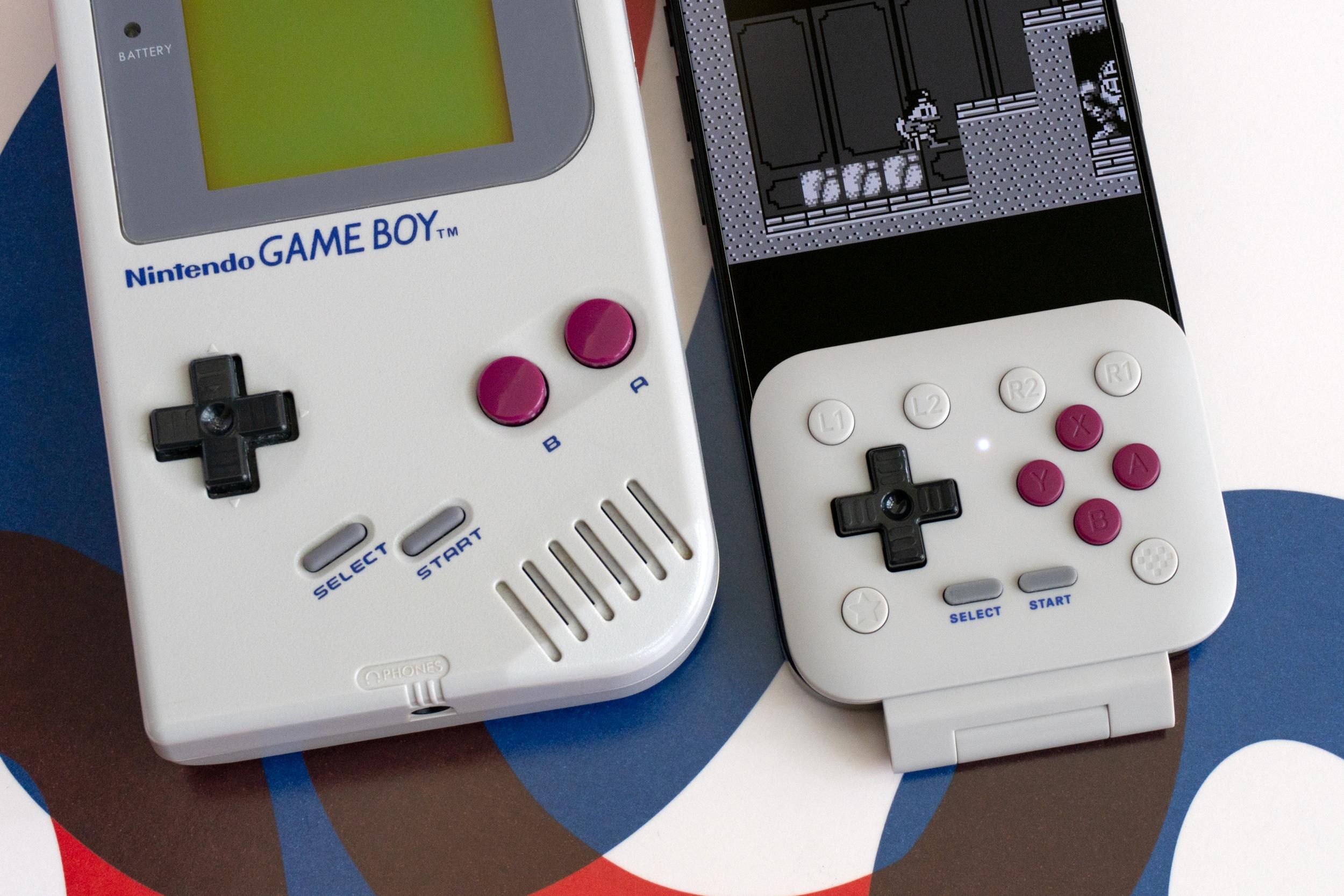 The 8BitDo FlipPad connected to an iPhone next to a Nintendo Game Boy.
