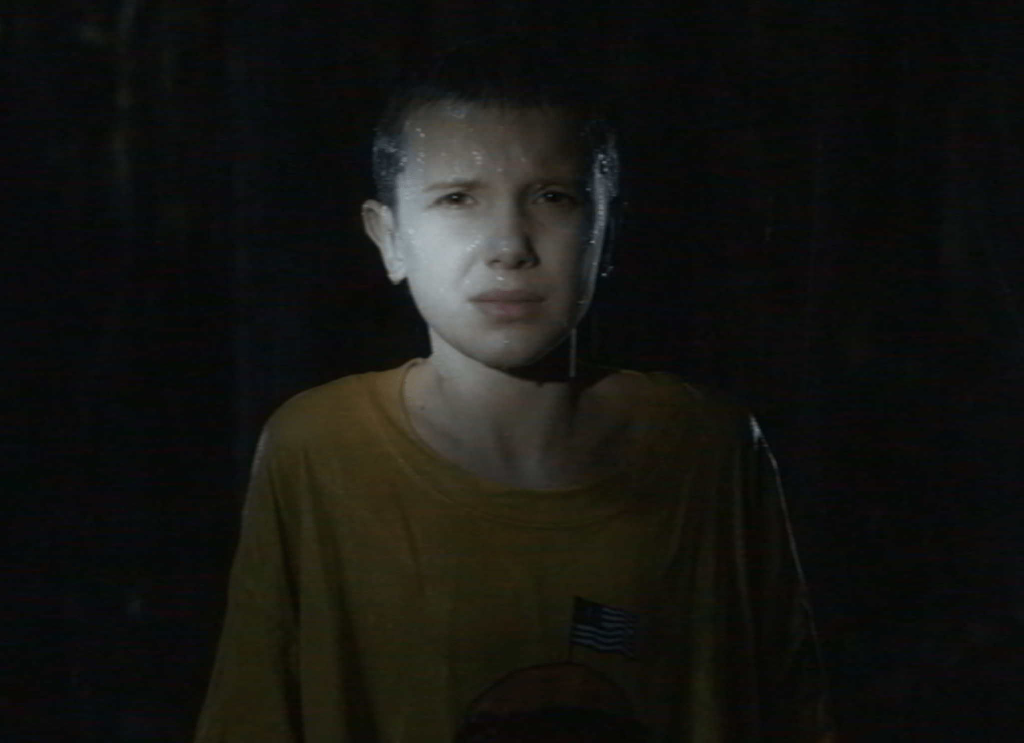 A still image of Eleven in the rain in the Netflix series Stranger Things.