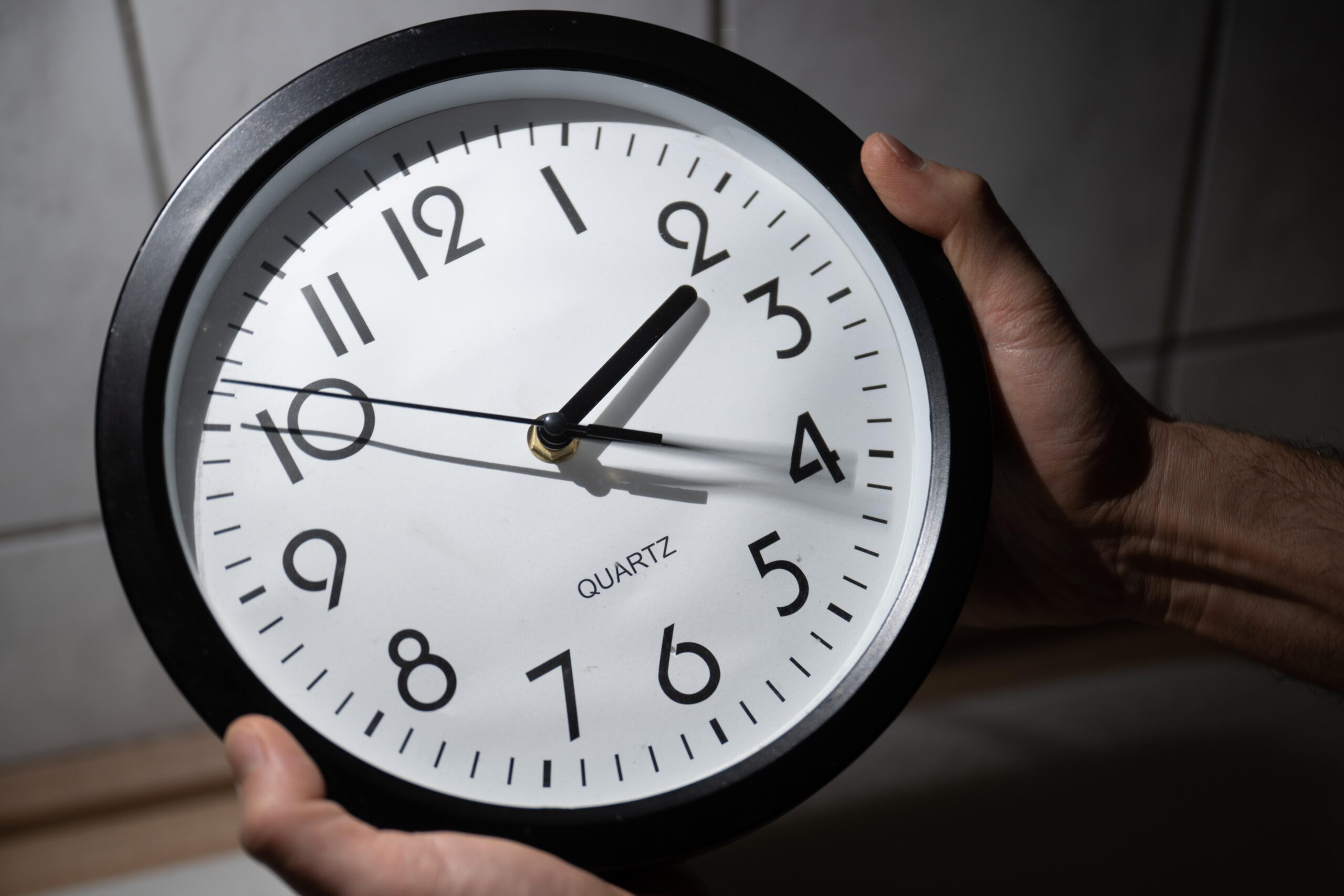 A photo of someone changing an analog clock