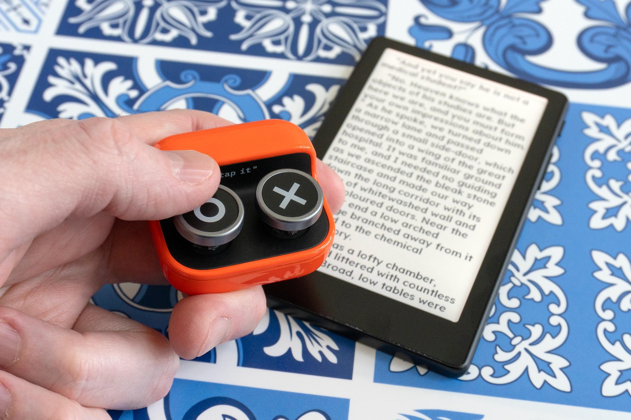 A person holding the Boox Tappy remote above the Xteink X4 Pro.