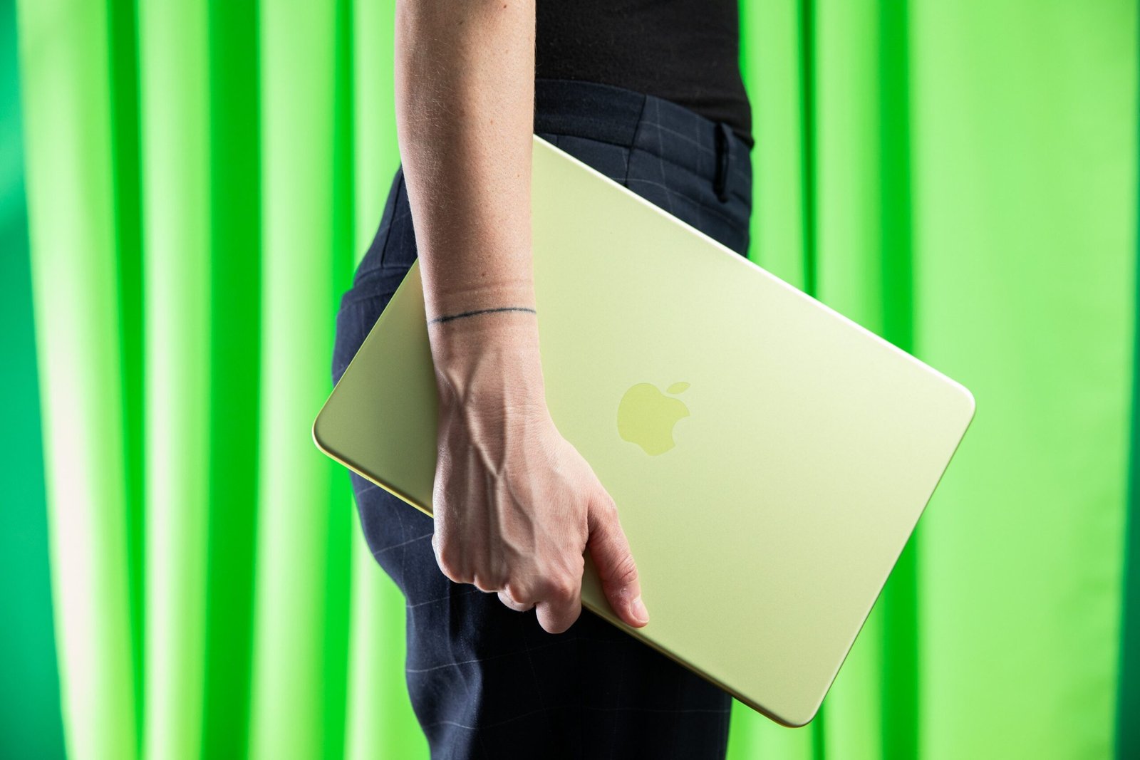 A person carrying a MacBook Neo.