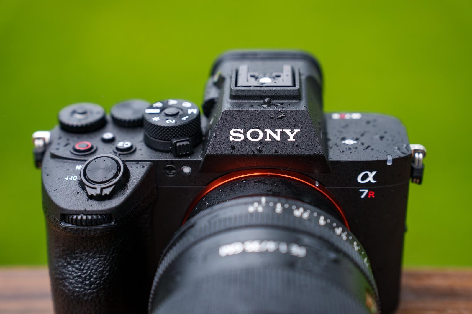 A close-up photo of the front of a Sony A7R VI camera with water droplets on it.