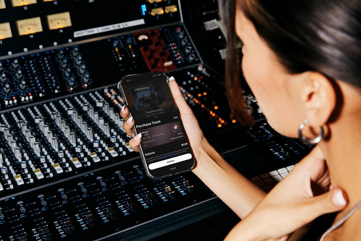 A woman using SoundCloud to purchase music.