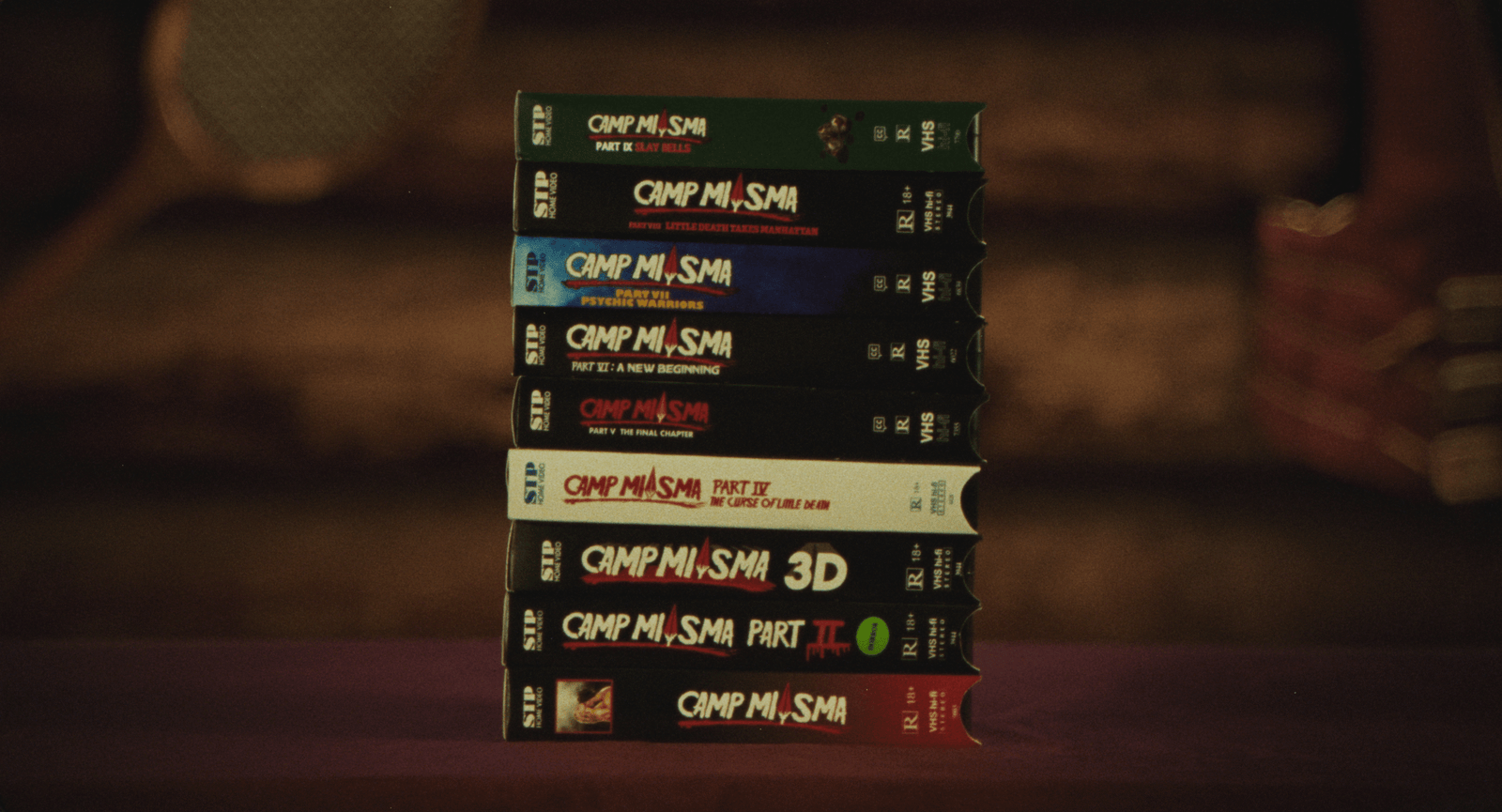 A still image of a stack of VHS tapes from the film Teenage Sex and Death at Camp Miasma.