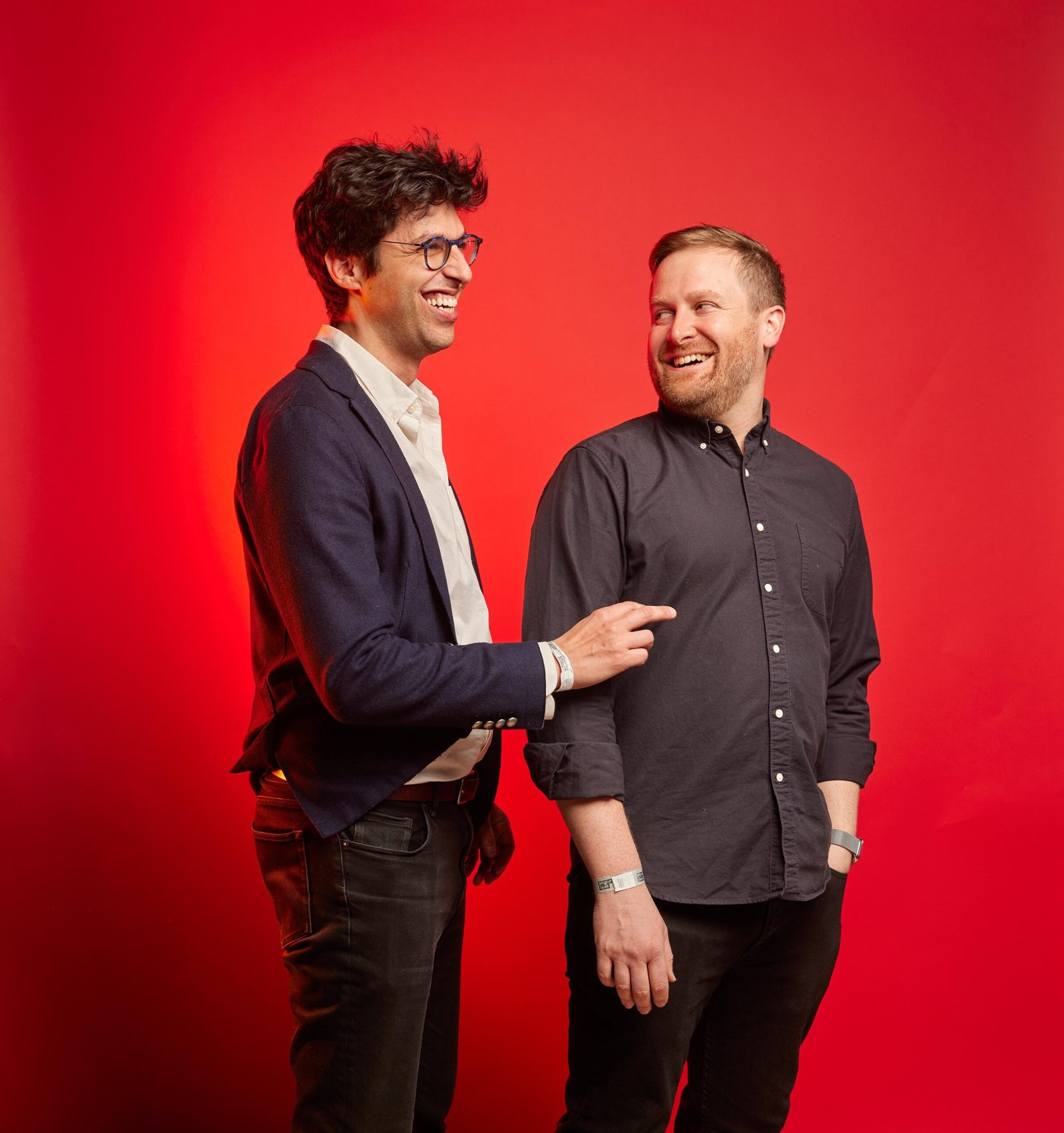 Switched on Pop’s Nate Sloan and Charlie Harding standing against a red background.