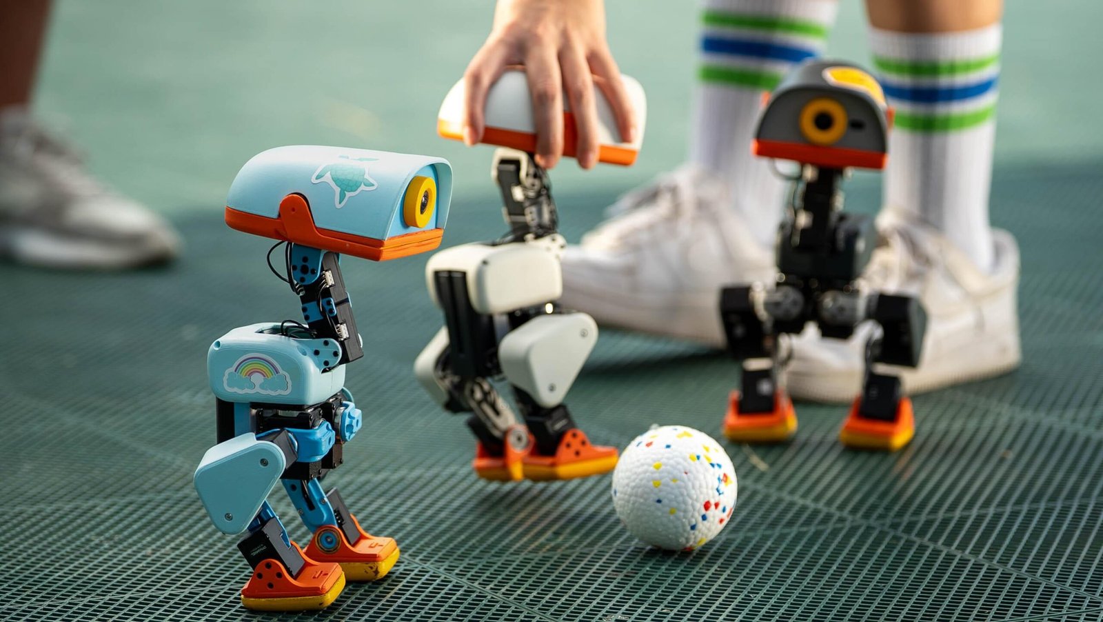 Three Microduck robots kicking a ball around