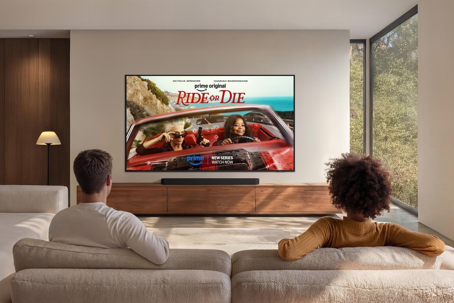 Two people watching Prime Video on a TV from a couch