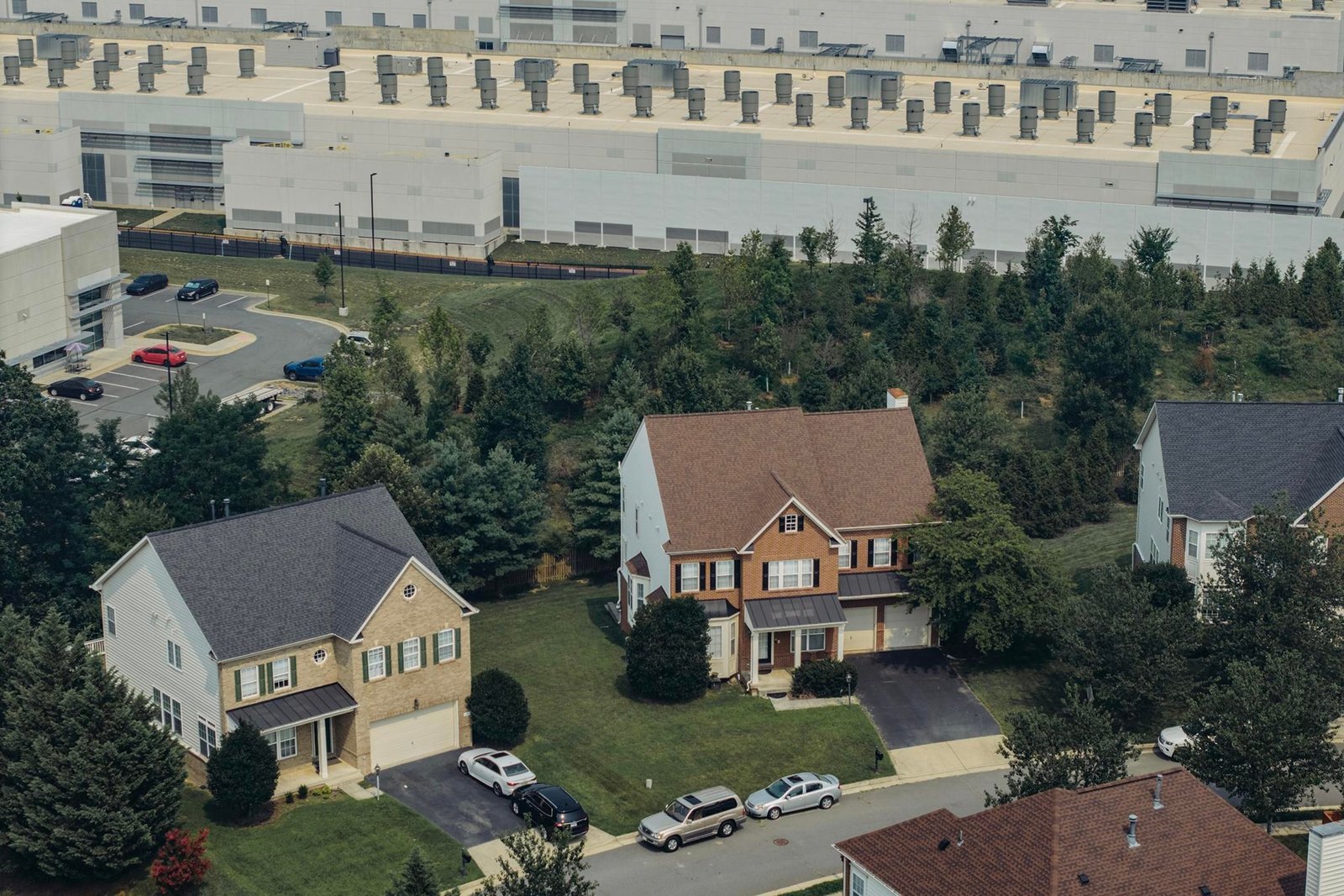 A neighborhood of nice houses in Sterling, Virginia, sits right next to a boxy and industrial-looking data center. A neighborhood of nice houses in Sterling, Virginia, sits right next to a boxy and industrial-looking data center.