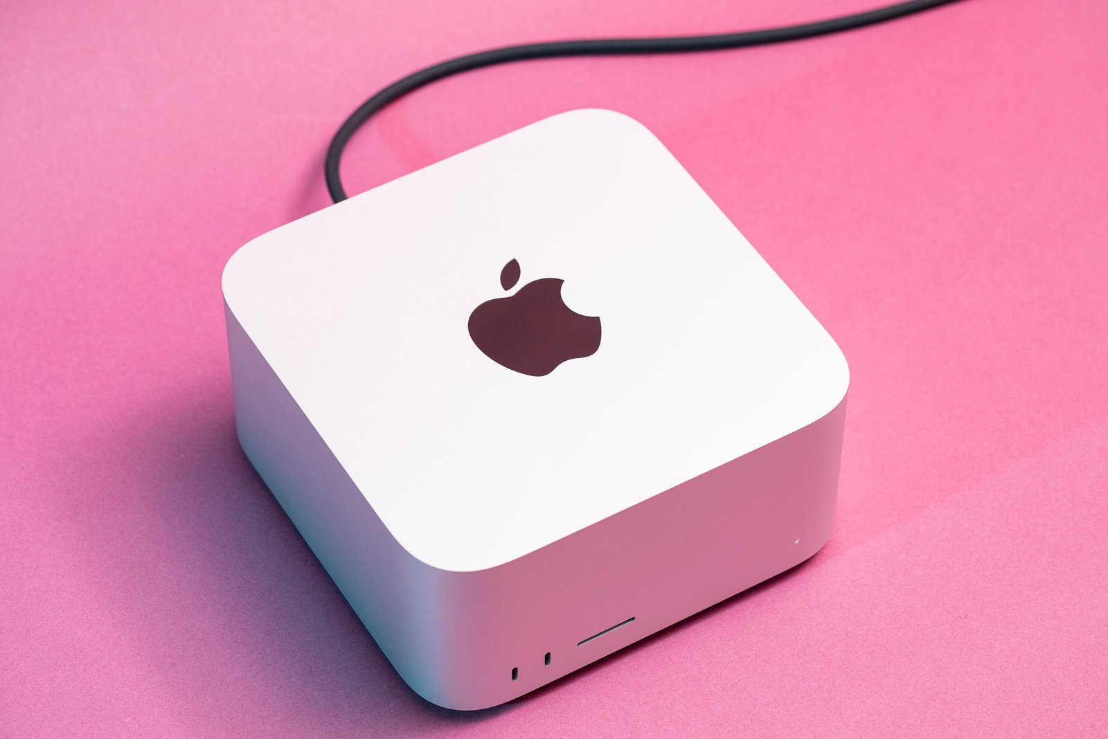 The Mac Studio seen from above on a pink background.