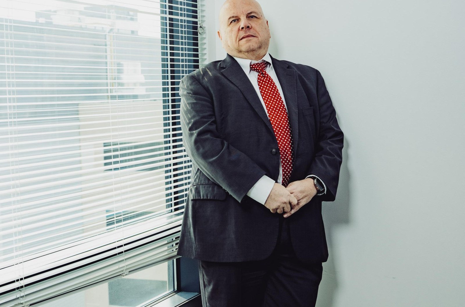 Buddy Rizer, an older man wearing a suit, poses for a portrait near the window in his office. Buddy Rizer, an older man wearing a suit, poses for a portrait near the window in his office.
