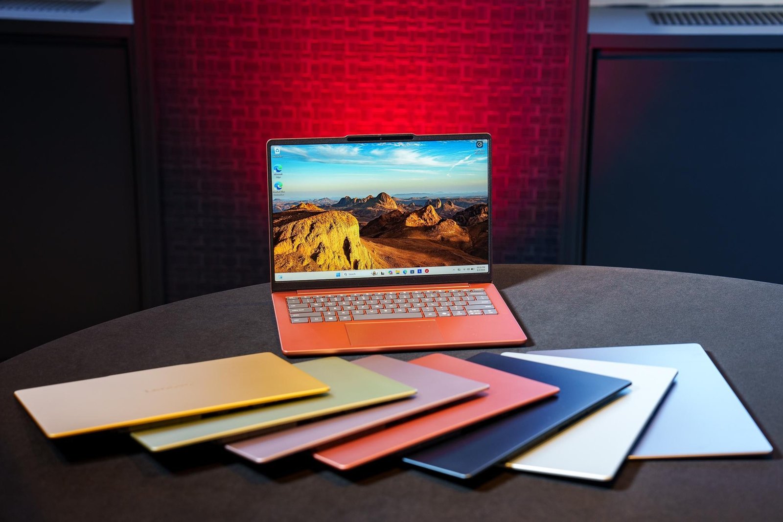 An orange Lenovo IdeaPad Vibe on a table with a swatch of its different colors.