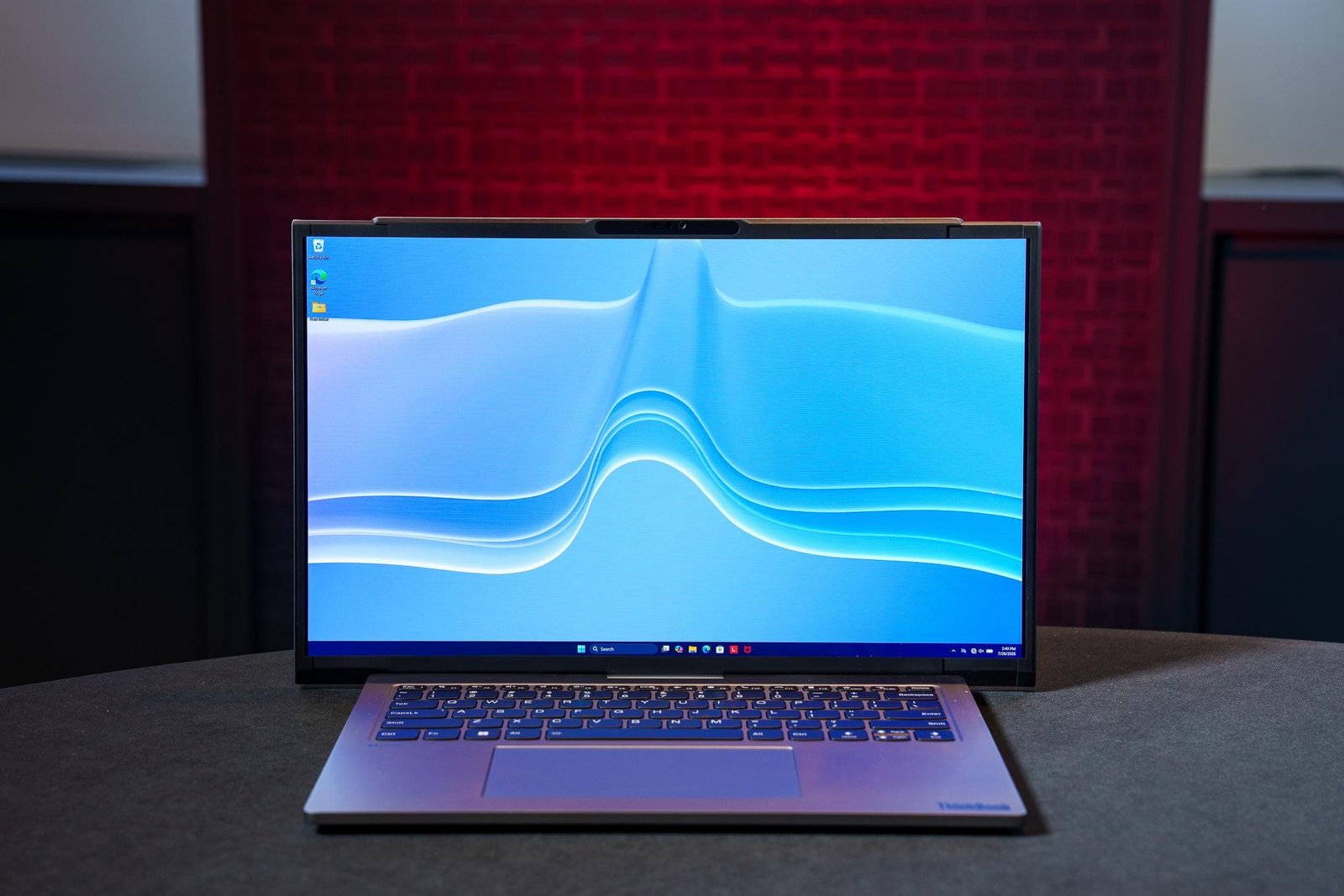 The rollable Lenovo ThinkBook Project Swan concept laptop sitting on a table with its screen expanded to 17 inches.