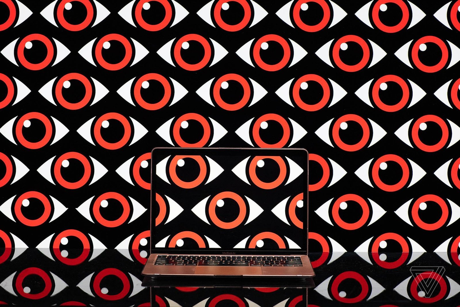 Art depicting a pattern of repeating eyeballs over a computer screen.