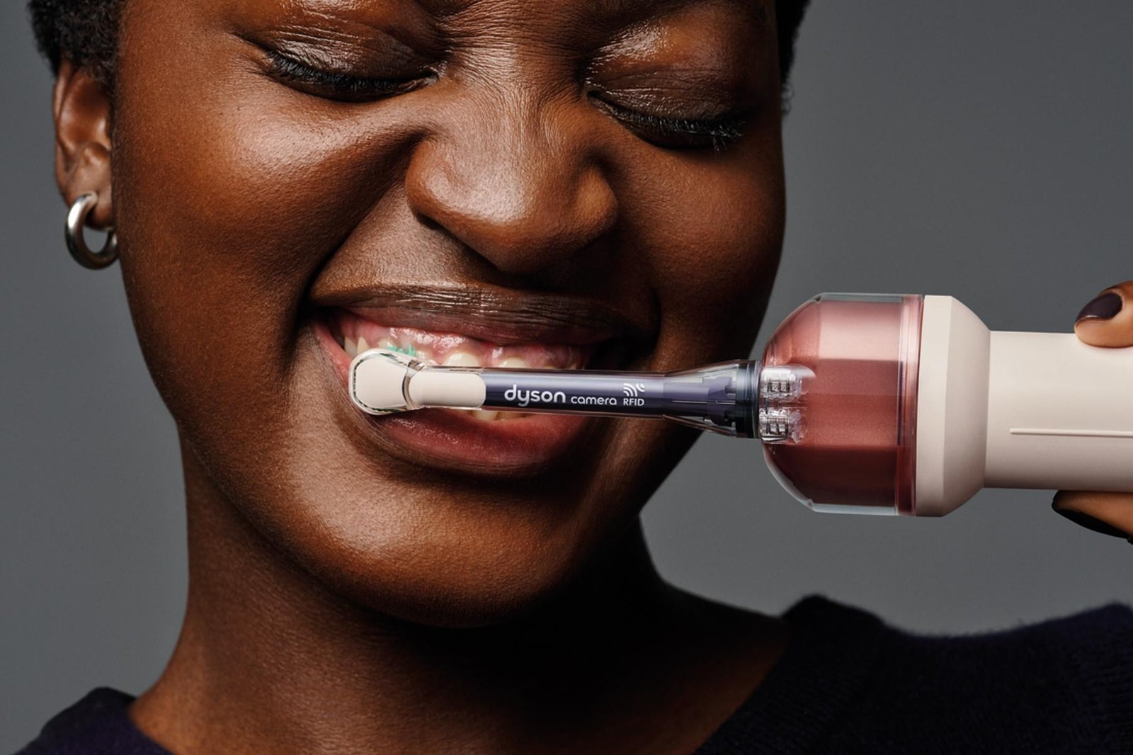A person brushes their teeth using the Dyson CameraJet smart toothbrush.