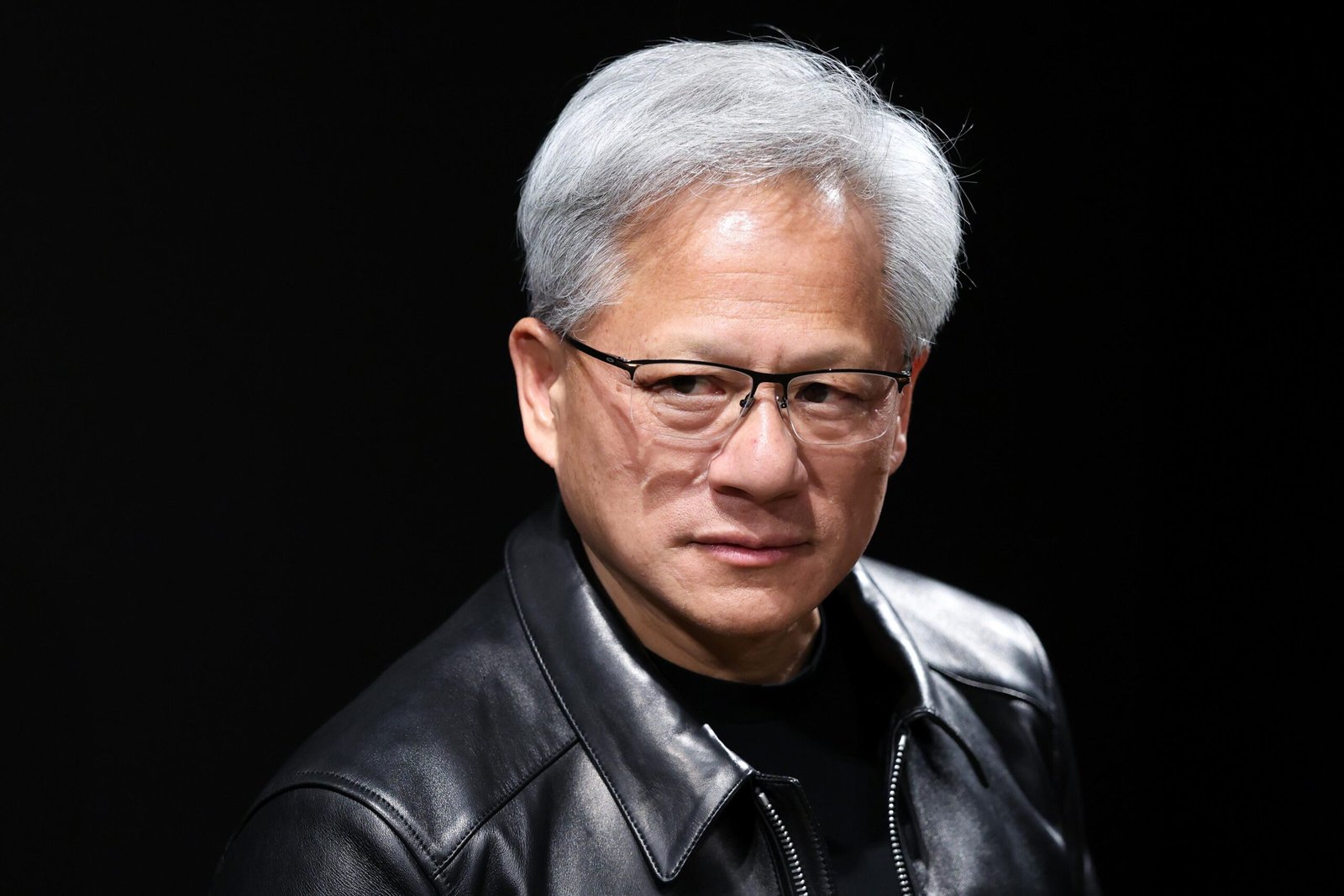A photo of Jensen Huang against a black background.
