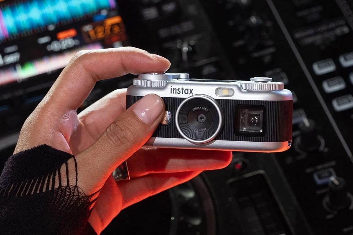 A person holds the Fujifilm Instax Pal 2 camera in one hand.
