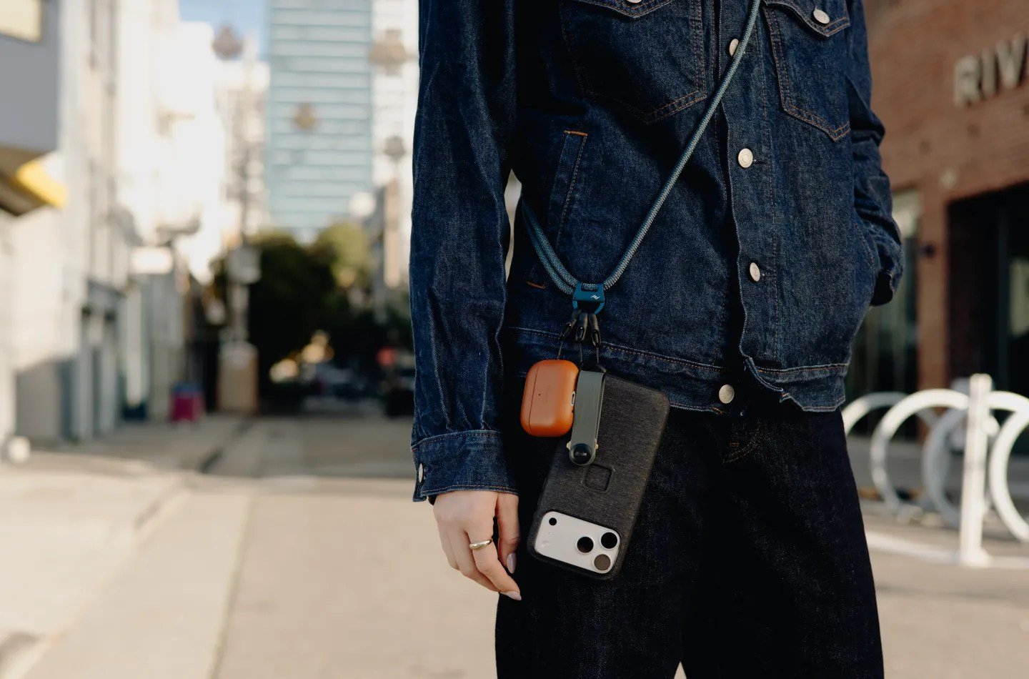 a person wearing a phone on a cross-body strap