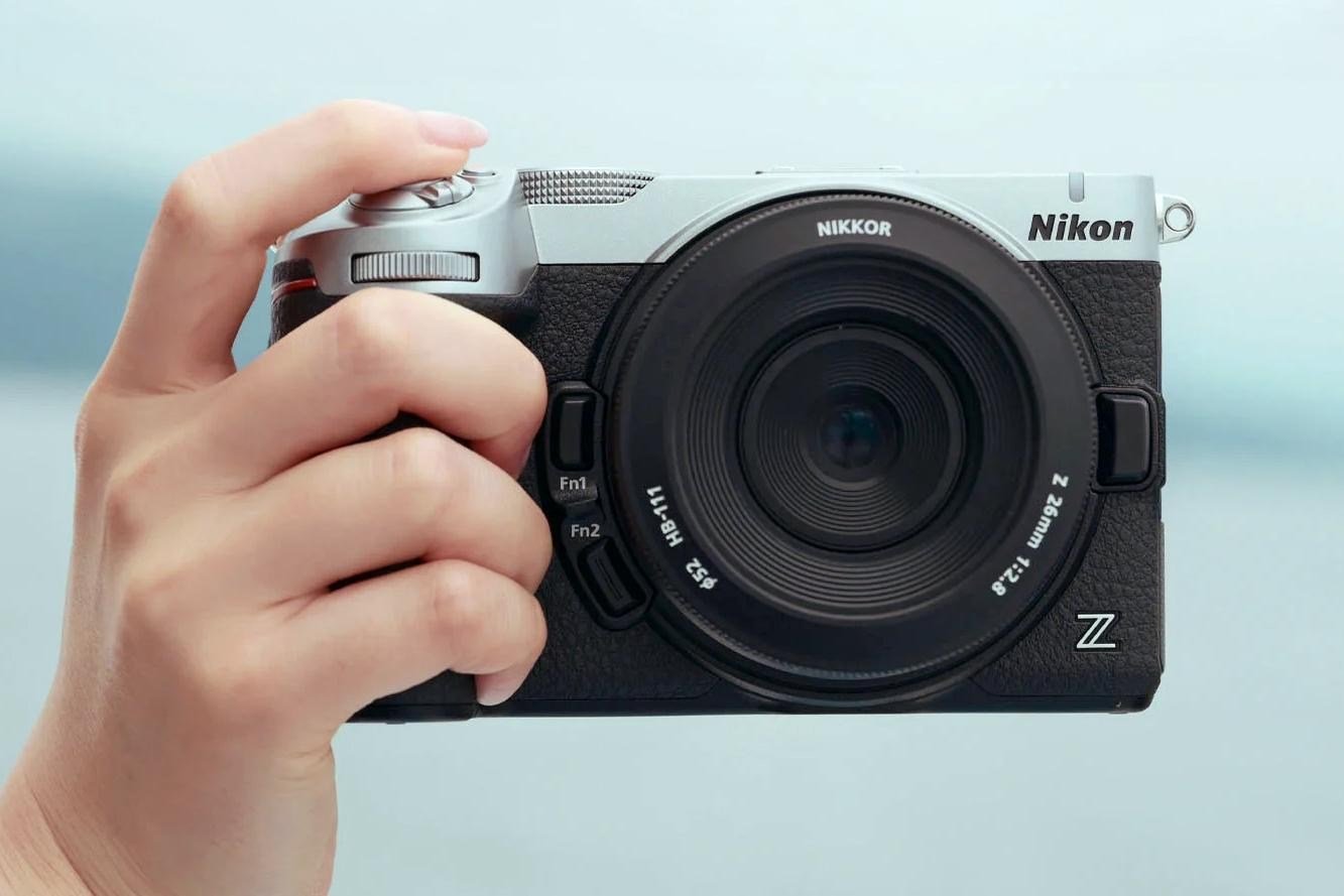 A person holds the Nikon Z5 IIC in one hand.