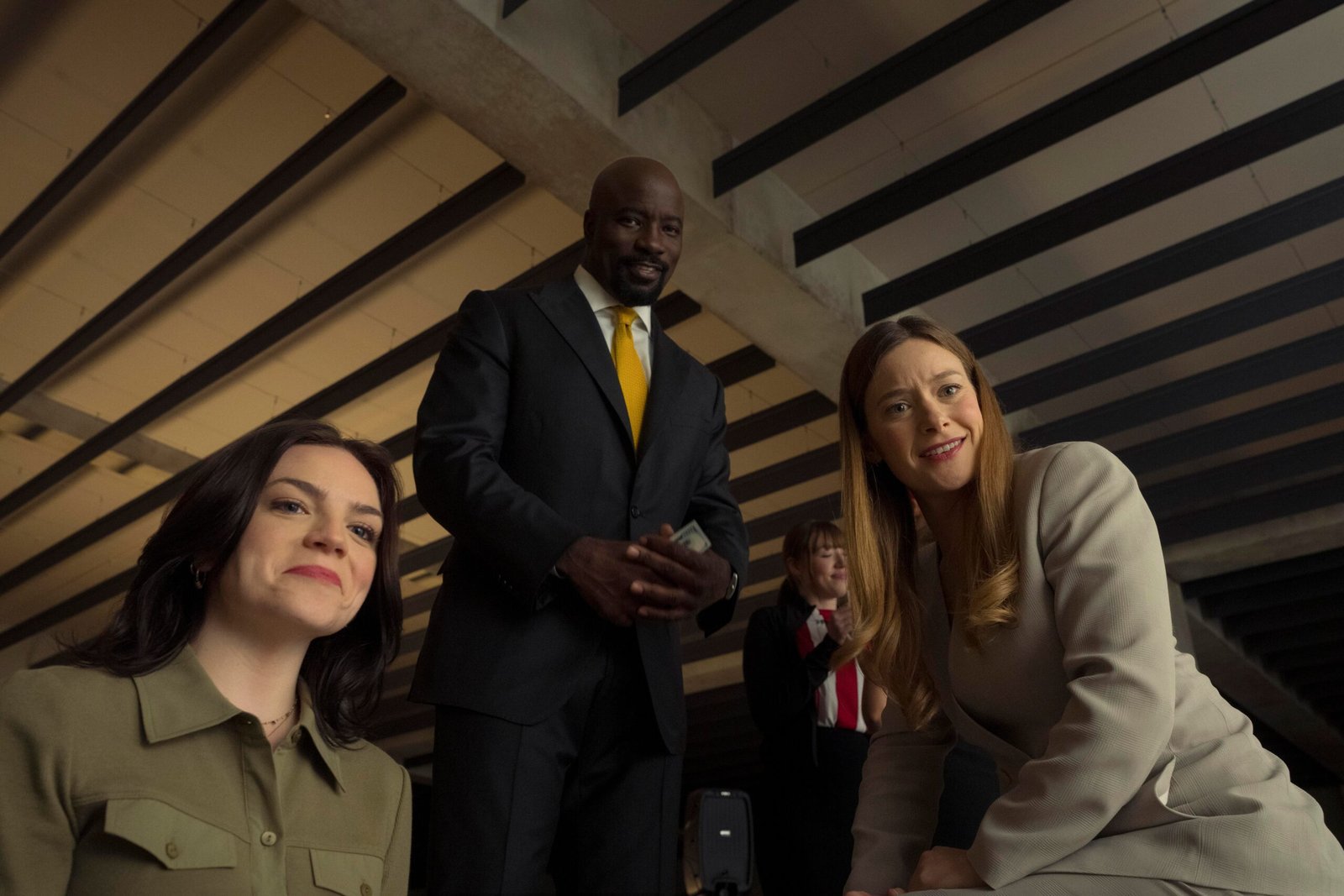 Three people in office wear from below looking down.