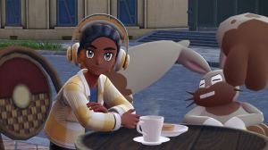 A Pokémon Legends: Z-A screenshot depicting a trainer and a Diggersby sitting at a table in front of a cafe.