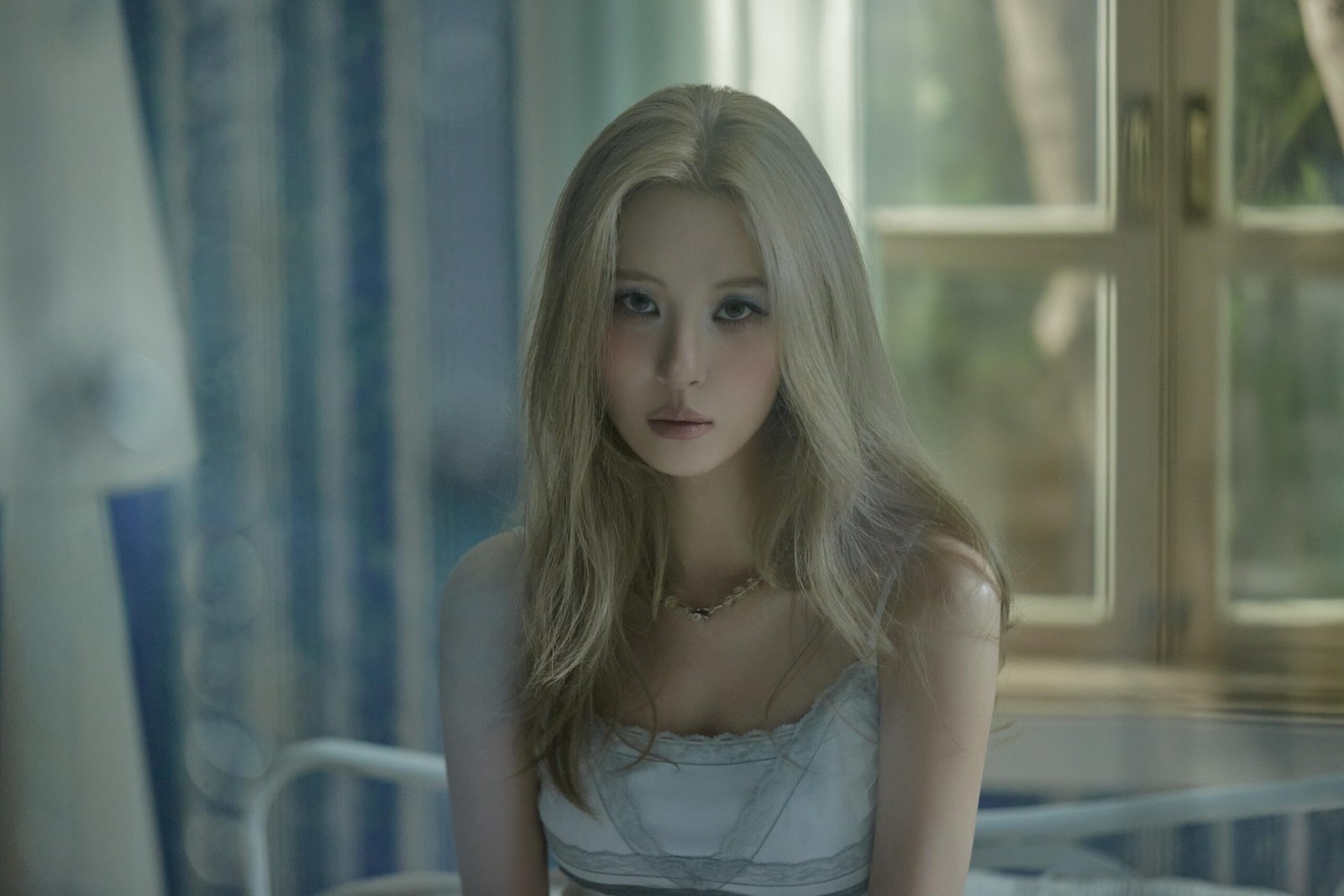 K-pop start Sunmi with blond hair in a very light blue dress in some very dreamy early morning light.
