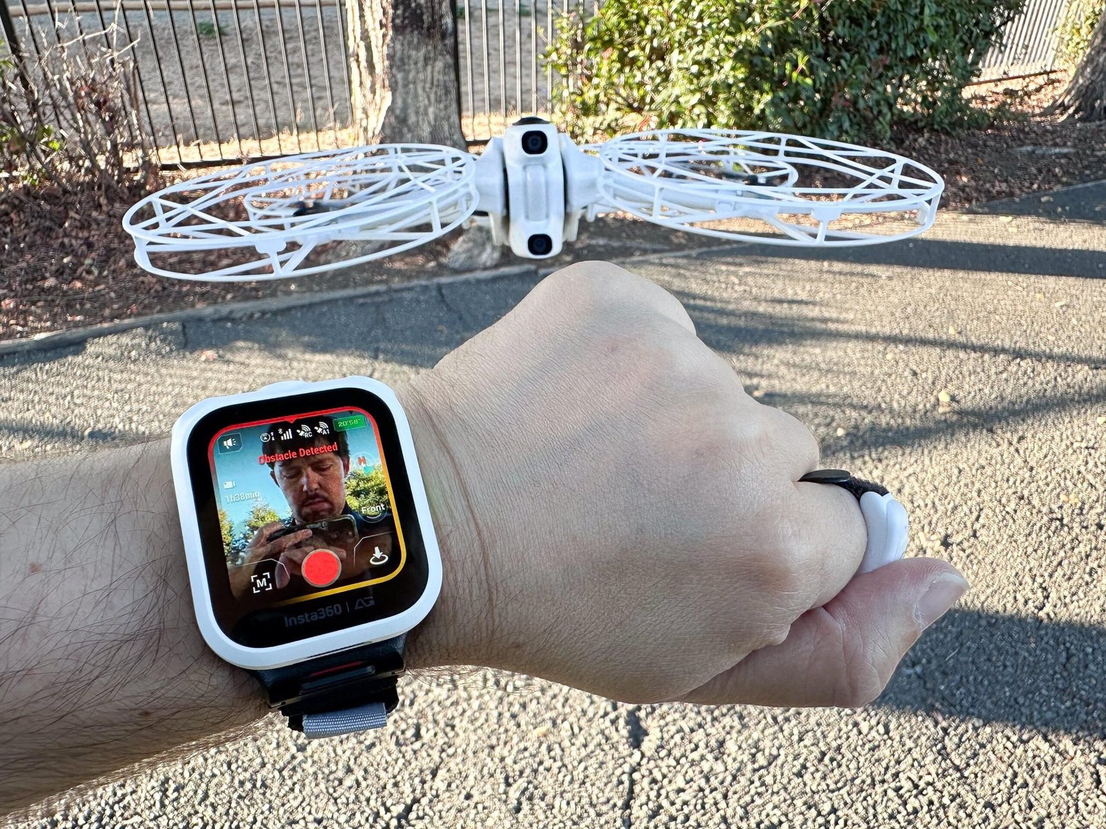 A wristwatch screen controls a drone flying right above the person’s hand.